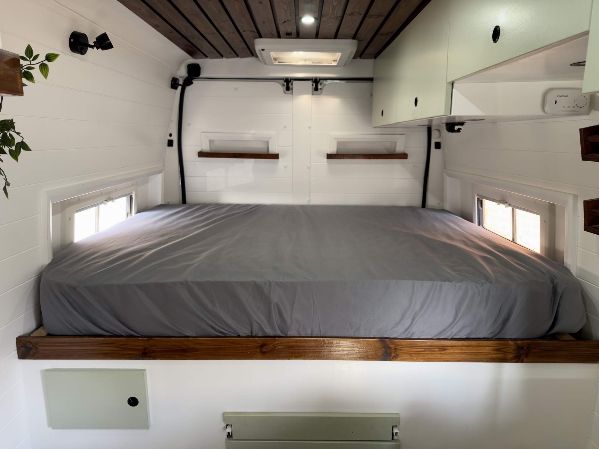 The custom mattress fitting snugly against the van walls with rounded corners
